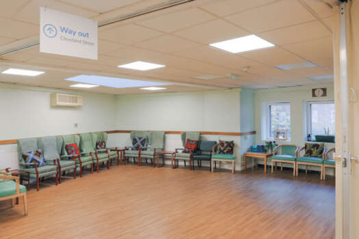 The Front Lounge at All Souls Clubhouse, set up with chairs around the edge of the room.