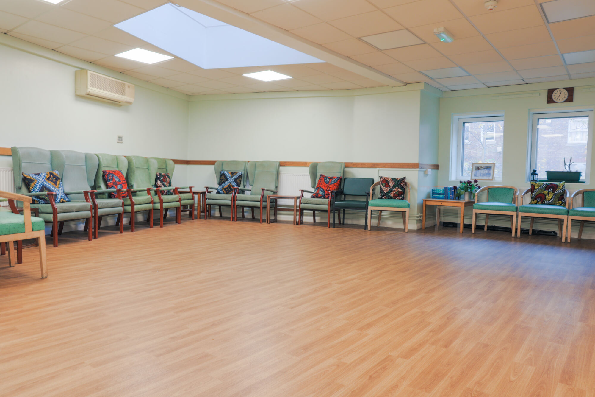 The Front Lounge at All Souls Clubhouse, set up with chairs around the edge of the room.